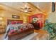 Cozy bedroom featuring wood paneling, wood-look floors, a ceiling fan and nice furnishings at 2911 Walker Rd, Lakeland, FL 33810