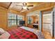 Bedroom features wood paneling, natural light, a closet mirror door, and a ceiling fan at 2911 Walker Rd, Lakeland, FL 33810
