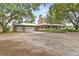 Charming home features a wraparound porch, stone chimney, detached three-car garage and gravel driveway at 2911 Walker Rd, Lakeland, FL 33810