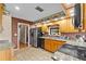 Kitchen featuring granite countertops, wooden cabinetry, stainless steel appliances, and brick wall accents at 2911 Walker Rd, Lakeland, FL 33810