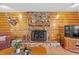 Cozy living room with a stone fireplace, wood paneling, and a decorative deer head on the wall at 2911 Walker Rd, Lakeland, FL 33810