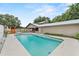 Outdoor pool with a white fence, landscaping, and lounge chairs in the backyard at 2911 Walker Rd, Lakeland, FL 33810