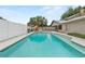 Backyard pool featuring light blue water and tile trim surrounded by fencing and the rear of the home at 2911 Walker Rd, Lakeland, FL 33810