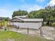 Home's rear exterior showcases the yard's privacy fence and charming screened-in porch, surrounded by natural beauty at 2911 Walker Rd, Lakeland, FL 33810