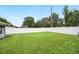 The backyard offers a large grassy area surrounded by a white fence, perfect for outdoor activities at 3080 Cross Fox Dr, Mulberry, FL 33860