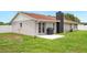 View of the home's backyard with concrete patio, gas grill, neutral paint color, and fenced yard at 3080 Cross Fox Dr, Mulberry, FL 33860