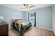 Cozy bedroom features wood-look floors, blue walls, ceiling fan and window with blue curtains at 3080 Cross Fox Dr, Mulberry, FL 33860