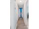 Hallway features wood floors with doors to the rooms and a door at the end with a blue curtain at 3080 Cross Fox Dr, Mulberry, FL 33860
