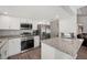 Bright kitchen showcasing granite counters, stainless appliances, white cabinets, and stylish, easy-care laminate flooring at 3080 Cross Fox Dr, Mulberry, FL 33860