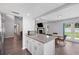 Open floor plan kitchen with granite island, stainless appliances, and view to dining area with backyard access at 3080 Cross Fox Dr, Mulberry, FL 33860
