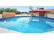 Relaxing in-ground pool with red umbrella provides enjoyment on hot days in a fenced yard at 3080 Cross Fox Dr, Mulberry, FL 33860