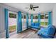 Bright sunroom with wood-look floors, white paneled ceiling, and comfortable blue seating at 3080 Cross Fox Dr, Mulberry, FL 33860