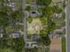 Aerial view of the home with a large yard, framed by lush trees and a quiet residential street at 320 W Carver St, Lakeland, FL 33805