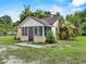 Quaint single-story home featuring a screened front porch and mature landscaping at 320 W Carver St, Lakeland, FL 33805
