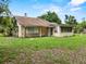 A view of the back of the home showing windows, trim, and lawn at 320 W Carver St, Lakeland, FL 33805