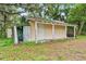 Small storage shed with sliding door and trim on the side of the home at 320 W Carver St, Lakeland, FL 33805