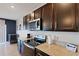 Well-lit kitchen with stainless steel appliances, granite counters and dark cabinets at 3685 Diving Dove Ln, Bartow, FL 33830
