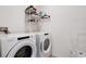 Functional laundry area includes a white washer and dryer with shelving for storage at 3685 Diving Dove Ln, Bartow, FL 33830