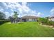 Expansive backyard featuring a screened lanai, verdant lawn, and mature landscaping for outdoor enjoyment at 4124 Prima Lago Cir, Lakeland, FL 33810