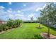 Spacious backyard featuring a lush lawn, mature landscaping, and serene outdoor space at 4124 Prima Lago Cir, Lakeland, FL 33810