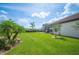Well-maintained backyard with tropical landscaping, a screened lanai, and ample green space at 4124 Prima Lago Cir, Lakeland, FL 33810