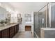 Well-lit bathroom with granite countertops, a glass-enclosed shower, and access to the main bedroom at 4124 Prima Lago Cir, Lakeland, FL 33810