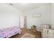 Bright bedroom features a crib, twin bed, and a decorative dollhouse and light wood flooring at 4124 Prima Lago Cir, Lakeland, FL 33810