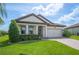 Charming single-story home featuring a well-manicured lawn and a stylish facade with a two car garage and tiled roof at 4124 Prima Lago Cir, Lakeland, FL 33810