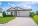 Inviting single-story home showcasing a meticulously maintained lawn and a charming facade with a brick driveway at 4124 Prima Lago Cir, Lakeland, FL 33810