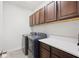 Laundry room featuring a modern washer and dryer with overhead cabinets at 4124 Prima Lago Cir, Lakeland, FL 33810