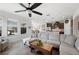 Inviting living room showcasing neutral decor, a ceiling fan, and seamless flow into the kitchen and dining areas at 4124 Prima Lago Cir, Lakeland, FL 33810