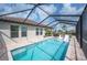 A luxurious screened pool features submerged lounge chairs, dining, and clear blue water at 4124 Prima Lago Cir, Lakeland, FL 33810