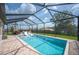 Wide view of the large, screened pool area and backyard featuring lounge seating and a dining set at 4124 Prima Lago Cir, Lakeland, FL 33810