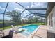 Screened-in pool area featuring lounge chairs and a beautiful backyard view with ample space for outdoor relaxation at 4124 Prima Lago Cir, Lakeland, FL 33810