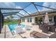 Screened-in pool area with a sparkling pool, lounge chairs, outdoor dining, and lush landscaping at 4124 Prima Lago Cir, Lakeland, FL 33810