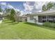 A partial view of the home's backyard space, including green grass and a small screened-in porch at 4926 Pleasant Hollow Trl, Lakeland, FL 33811