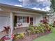 Inviting covered porch with vibrant landscaping, red shutters, and clean exterior at 4926 Pleasant Hollow Trl, Lakeland, FL 33811