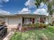 Exterior featuring lush front yard with vibrant landscaping, white siding, and red shutters at 4926 Pleasant Hollow Trl, Lakeland, FL 33811