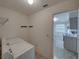 Laundry room features laundry machines, hooks for hanging, and tile flooring at 4926 Pleasant Hollow Trl, Lakeland, FL 33811