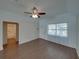 Open-concept living room with neutral paint, wood-look flooring, and a ceiling fan that complements the decor at 4926 Pleasant Hollow Trl, Lakeland, FL 33811