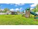 Large backyard featuring a wooden playset with slide, green lawn, and partial house view at 5316 Forestbrook E Dr, Lakeland, FL 33811