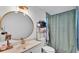 Bathroom features a round mirror, modern vanity, and shower with stylish curtain, creating a serene and functional space at 5316 Forestbrook E Dr, Lakeland, FL 33811