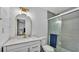 Bathroom featuring shiplap accent wall, a white vanity with gold fixtures, and a tiled walk-in shower at 5316 Forestbrook E Dr, Lakeland, FL 33811