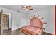 Bright bedroom featuring modern ceiling fan, wood-look floors, and a whimsical sun mural, creating a cheerful space at 5316 Forestbrook E Dr, Lakeland, FL 33811