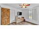 Bedroom features wood-look floors, ceiling fan, closet and a bright window, creating a functional and inviting retreat at 5316 Forestbrook E Dr, Lakeland, FL 33811