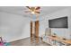 Spacious bedroom with stylish wood-look floors, modern ceiling fan, closet, and a bright window at 5316 Forestbrook E Dr, Lakeland, FL 33811