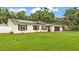 Charming single-story home with a well-maintained lawn, white fence, and modern solar panels at 5316 Forestbrook E Dr, Lakeland, FL 33811