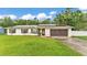 Charming single-story home with a well-maintained lawn, a two-car garage, and modern solar panels at 5316 Forestbrook E Dr, Lakeland, FL 33811