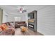 Cozy living room featuring shiplap walls, a brown leather sectional sofa, and an electric fireplace at 5316 Forestbrook E Dr, Lakeland, FL 33811
