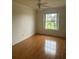 Inviting bedroom with hardwood floors, ceiling fan, and a window offering views of the outdoors at 5480 Summerland Hills Dr, Lakeland, FL 33812